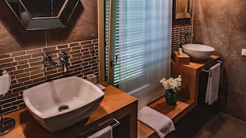 Ein modernes Badezimmer mit einem großen, weißen Waschbecken, einem Spiegel und einer Holzausstattung.