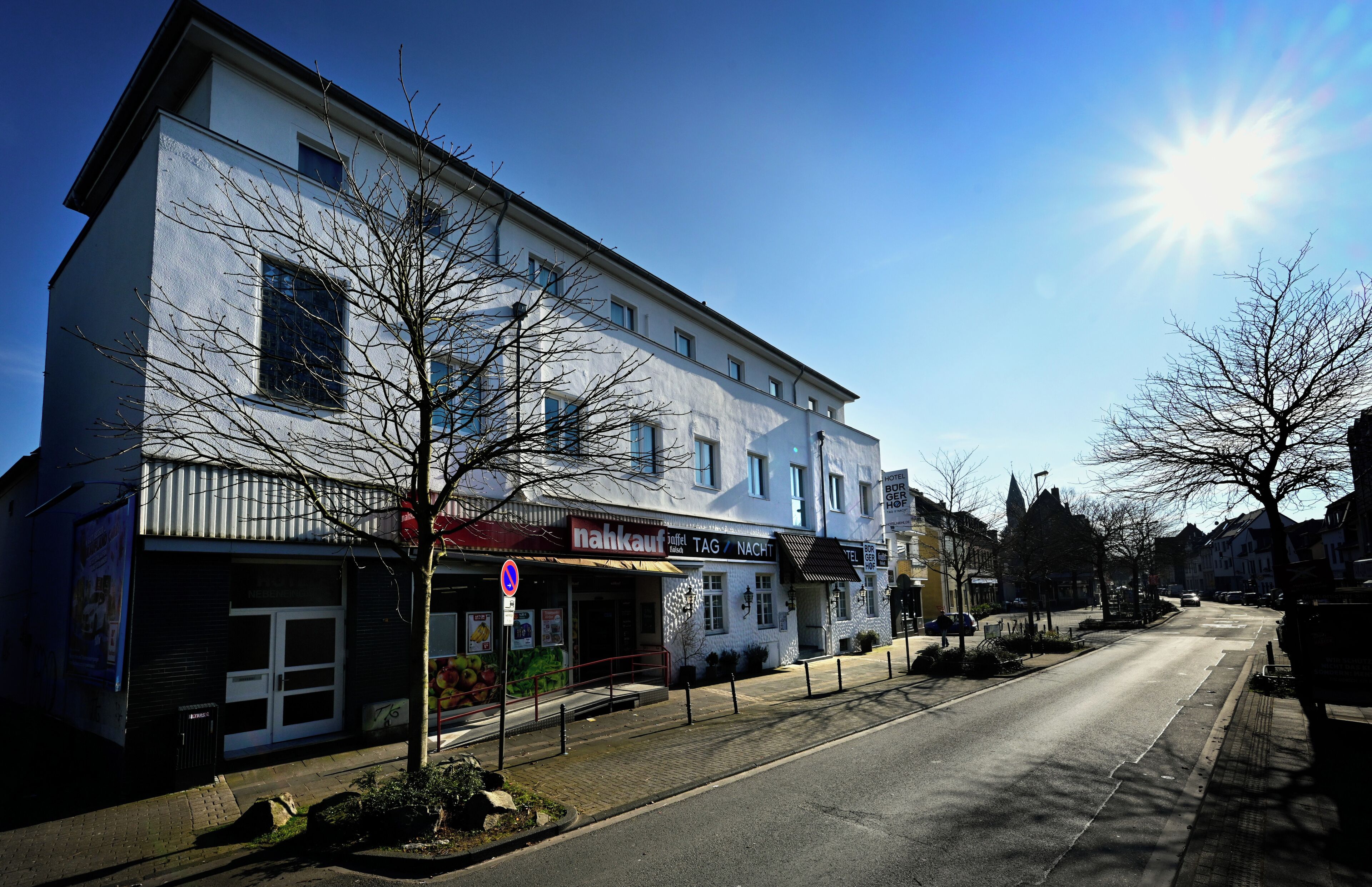 A two-story building with a restaurant named 'nahkauf' on the ground floor, featuring a large window display and a clear sky.