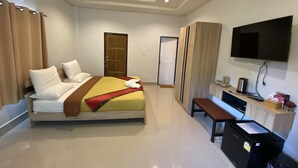 A hotel room with a bed, a desk, a television, and a wardrobe.