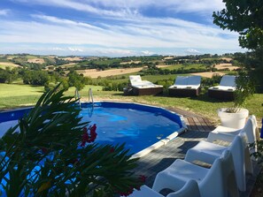Una piscina al aire libre, sillones reclinables de piscina