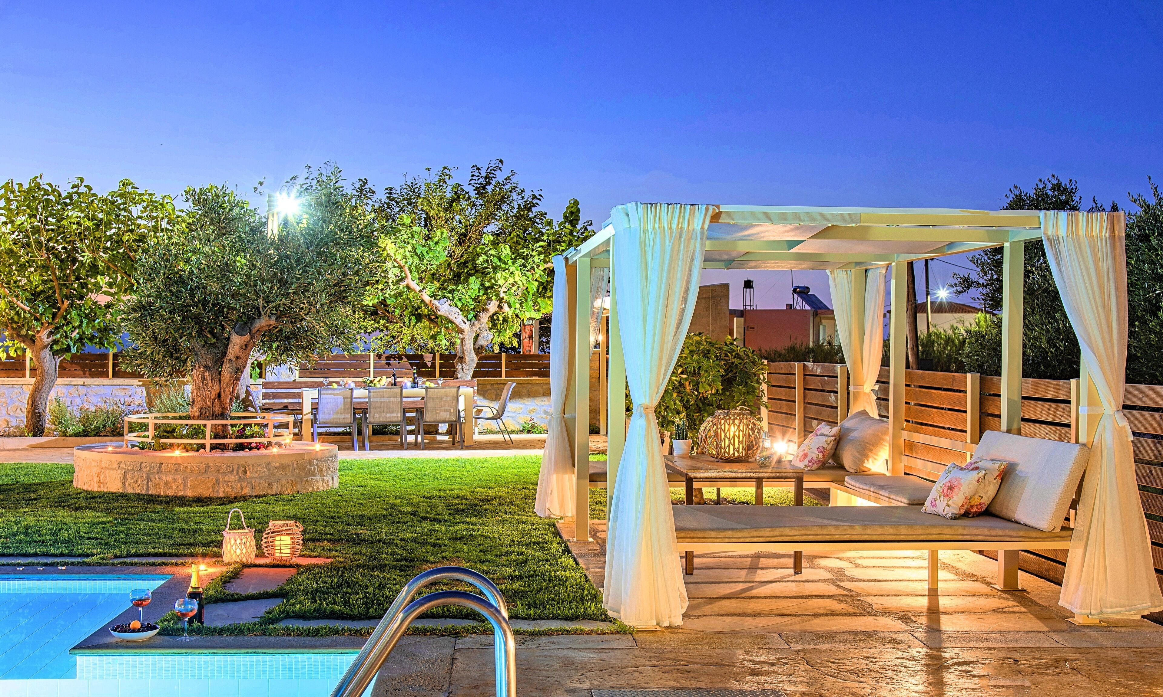 A poolside area with a covered seating area, a stone fountain, and a pool.