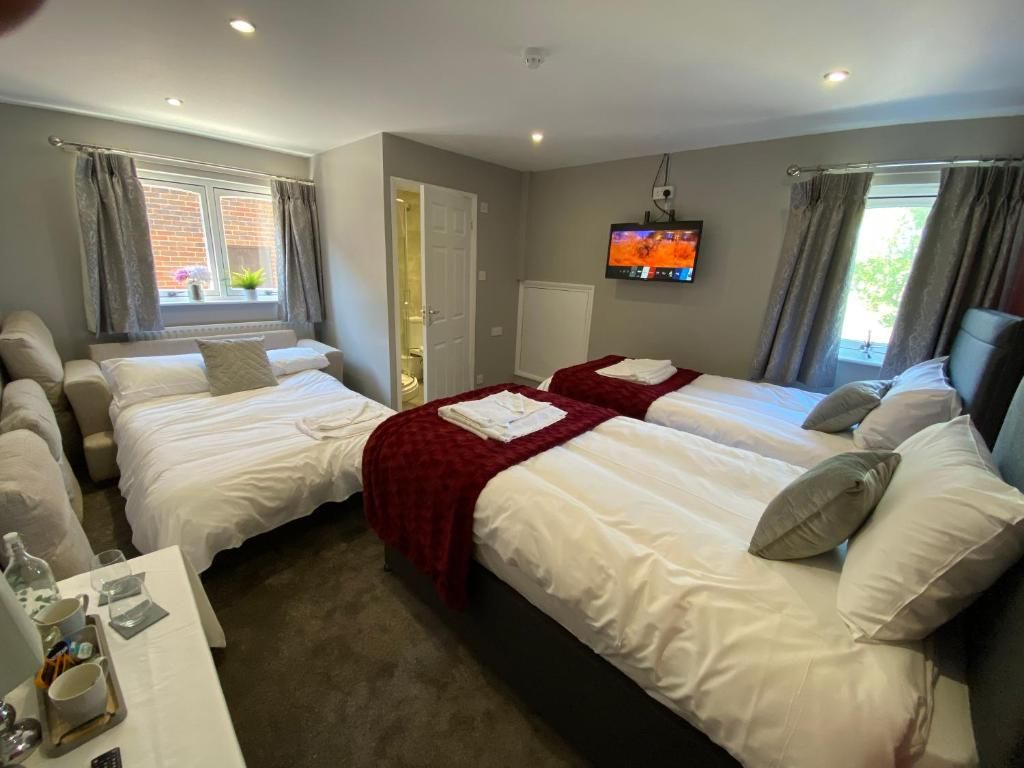 A hotel room with two beds, a TV, and a small table with a tray.