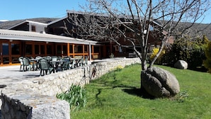 Un bâtiment doté d’un mur en pierre et d’un espace extérieur aménagé pour s’asseoir.