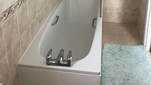 A bathroom with a bathtub, a shower, and a towel rack. - Viking Guest House (Bridlington)