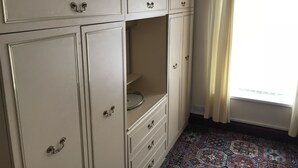 A room with a large wardrobe, a patterned carpet, and a window with curtains. - Viking Guest House (Bridlington)