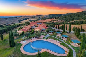 A villa with a swimming pool, outdoor seating, and a view of rolling hills. - Dimora Santa Margherita - Boutique Hotel (Cinigiano)