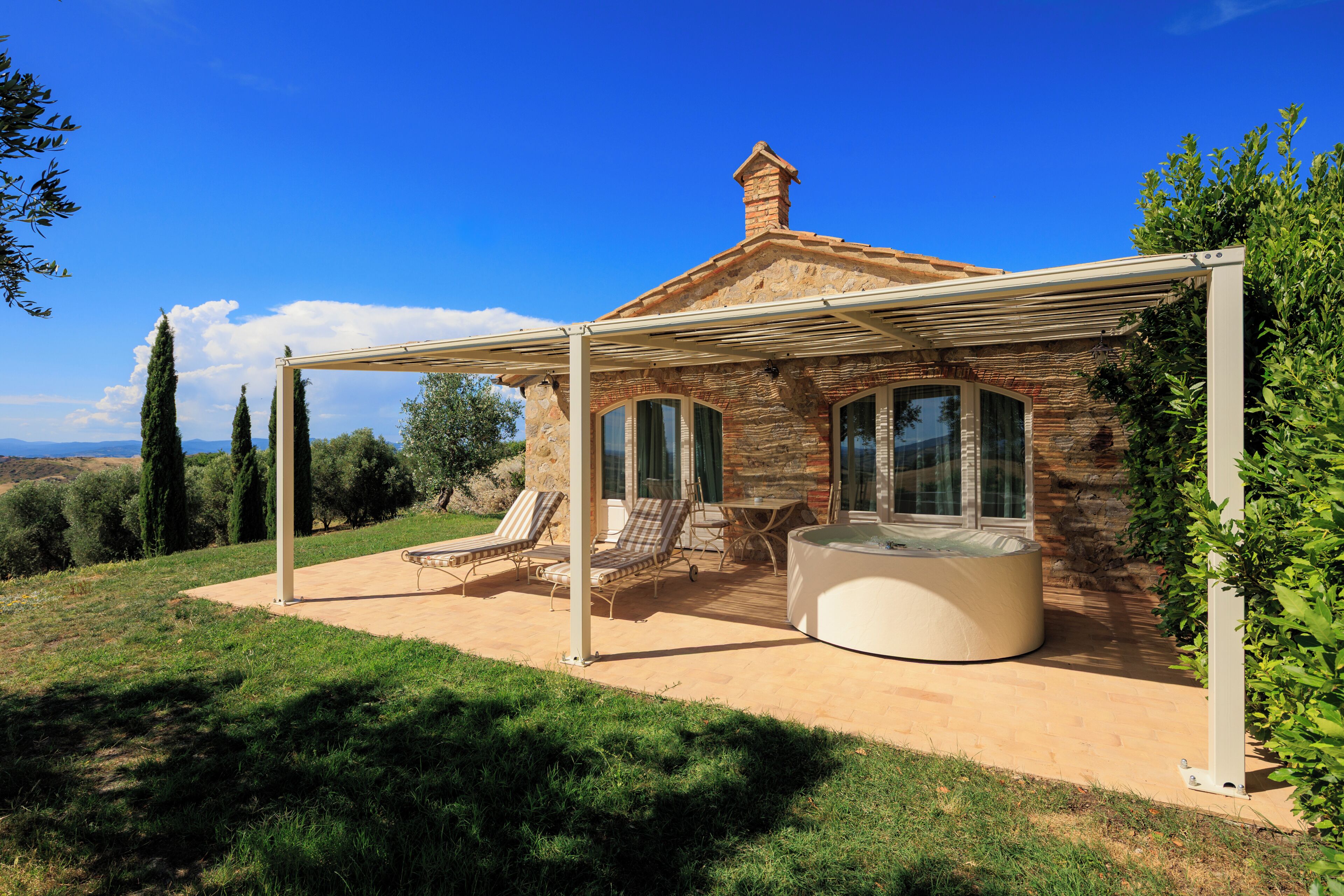 A house with a covered patio, outdoor seating, and a hot tub.