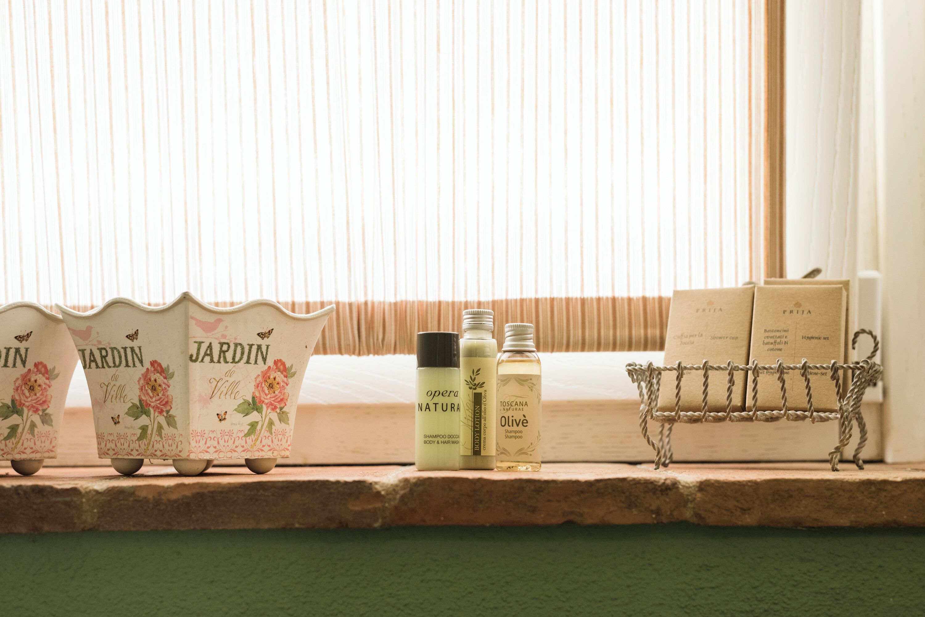 Uma prateleira com três frascos de shampoo e duas nécessaires.