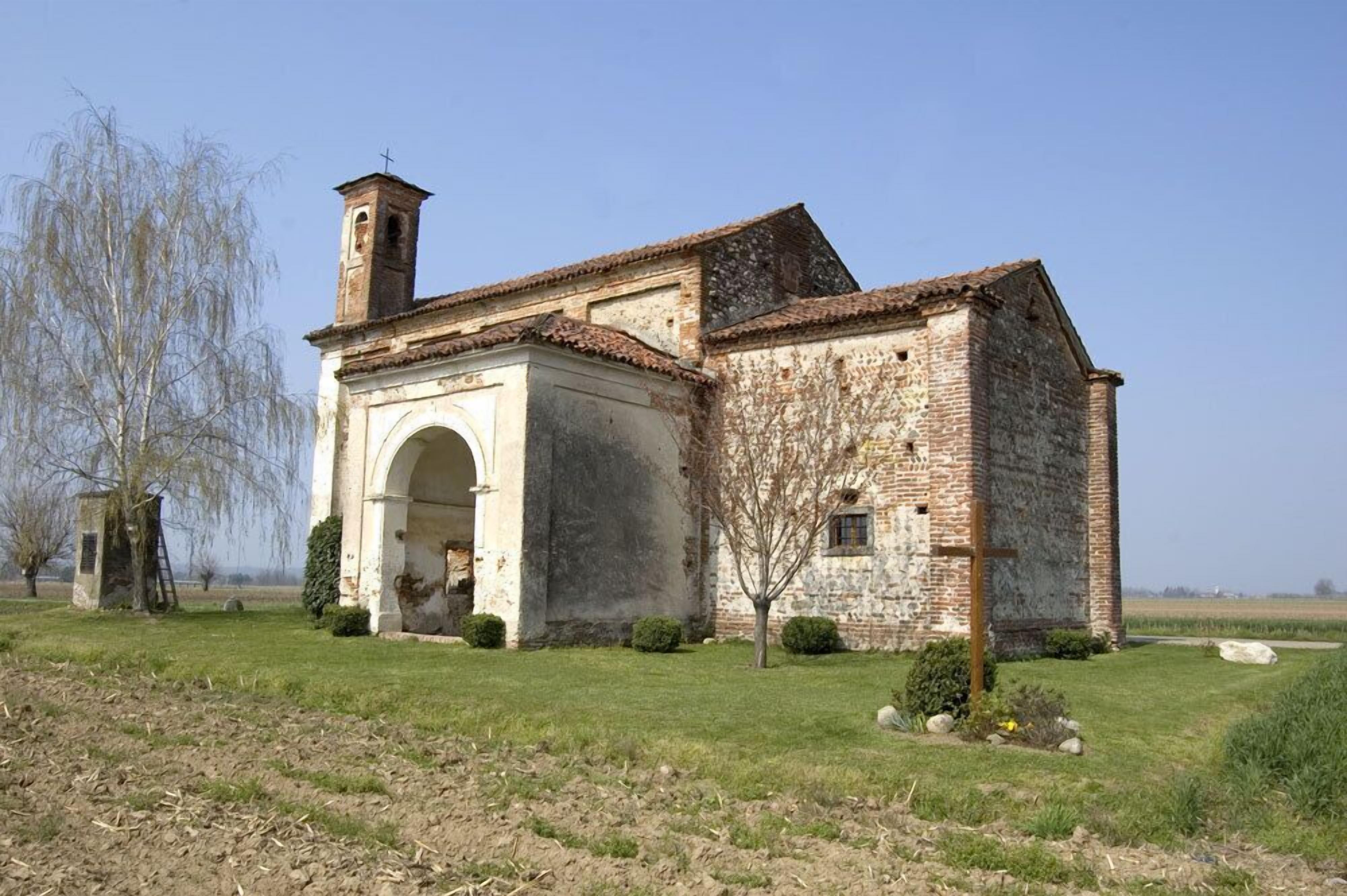 Une vieille église en pierre, dotée d’un clocher, d’une entrée en arc de cercle et d’une petite cloche.
