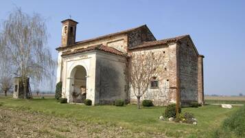 Une vieille église en pierre, dotée d’un clocher, d’une entrée en arc de cercle et d’une petite cloche.