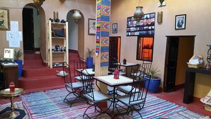 Um interior acolhedor com área de refeições, estante de livros e parede decorada com fotografias.