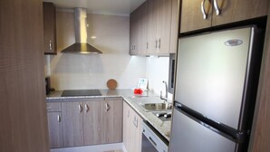 Eine moderne Küche mit Holzschränken, Edelstahlgeräten und einer Arbeitsplatte aus Granit.