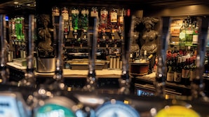 A bar area with various liquor bottles and two statues.
