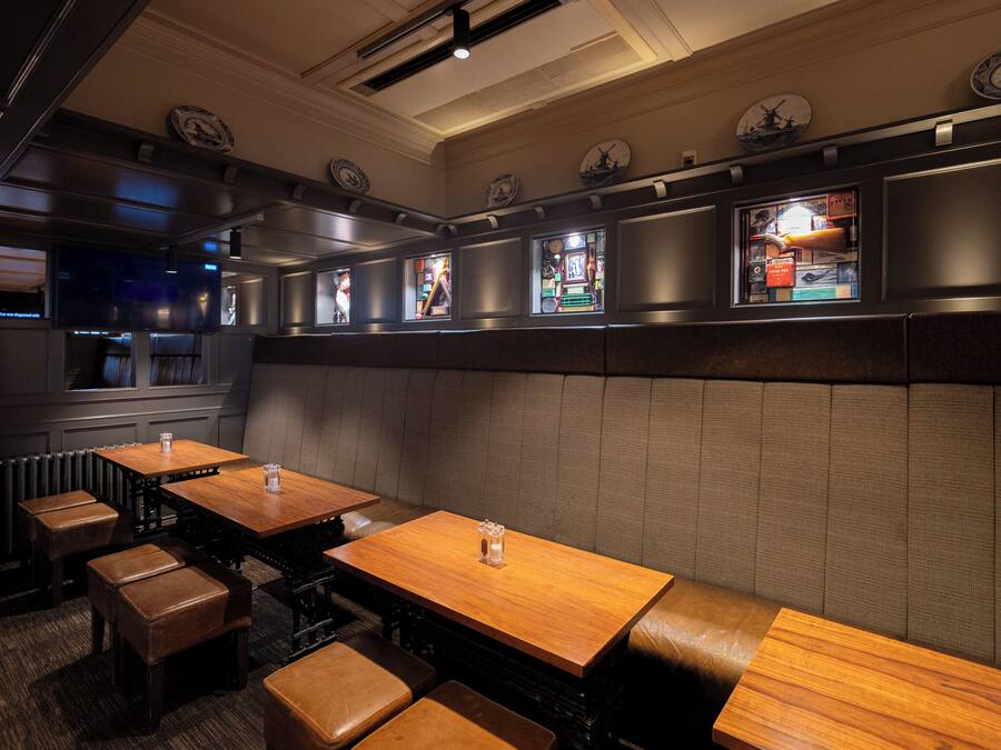 A restaurant interior with booths, wooden tables, and a counter.