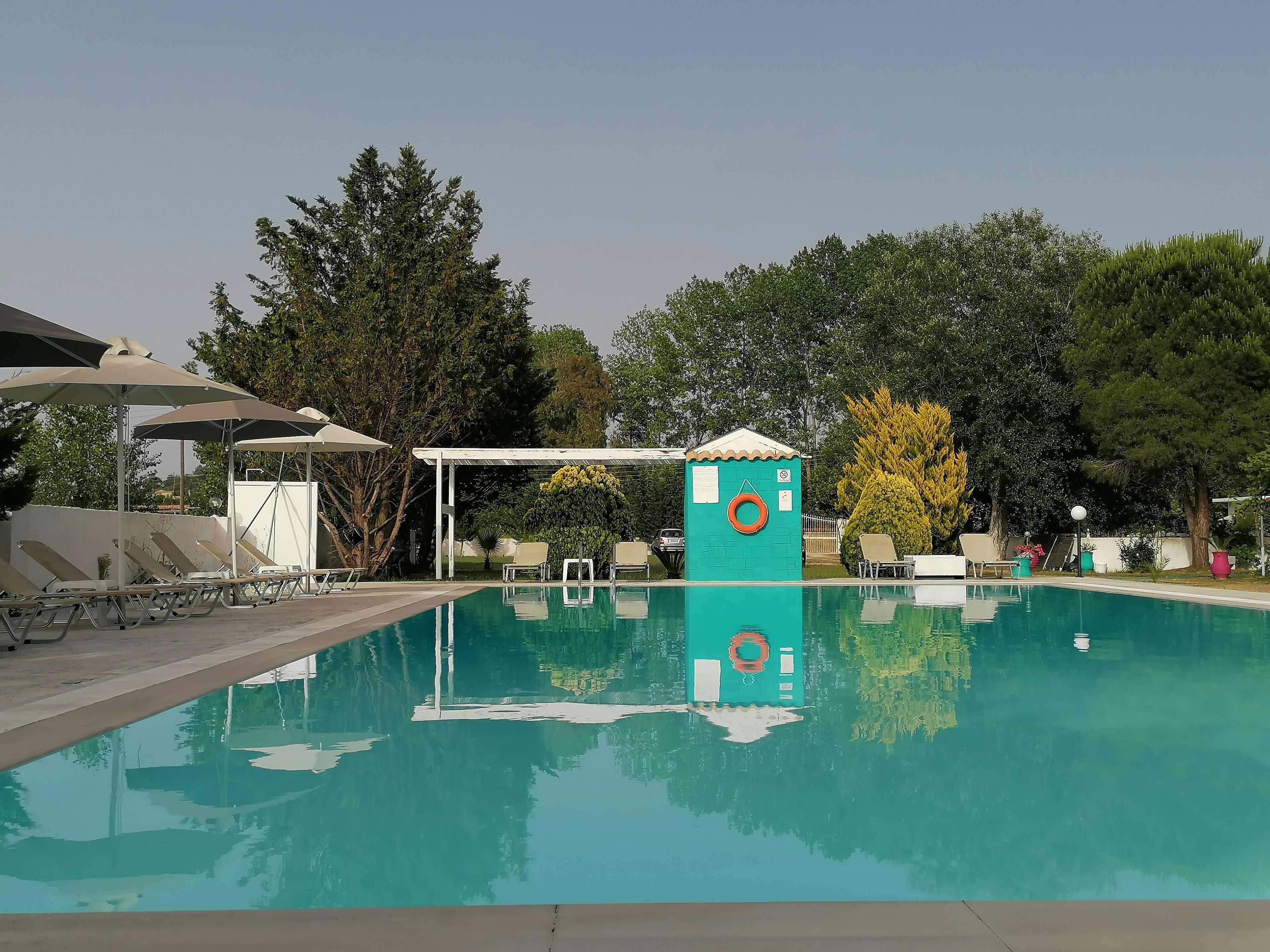 A swimming pool with lounge chairs and a lifeguard station.