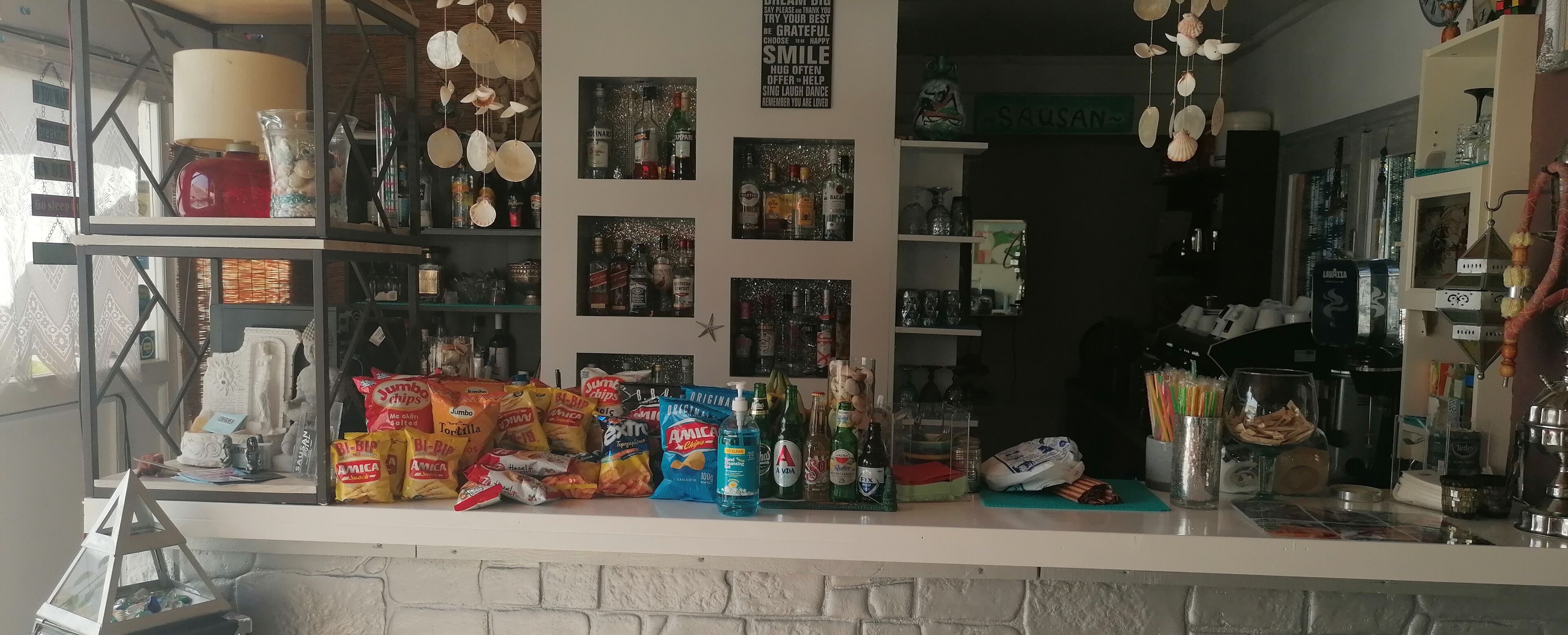 A counter with snacks, drinks, and a variety of bottles.