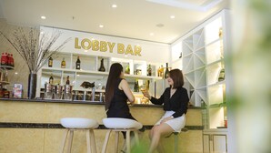 Um bar no lobby com uma placa que diz "LOBBY BAR" e prateleiras repletas de garrafas.
