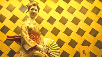 A traditional Japanese setting with a patterned background and a person in a kimono.