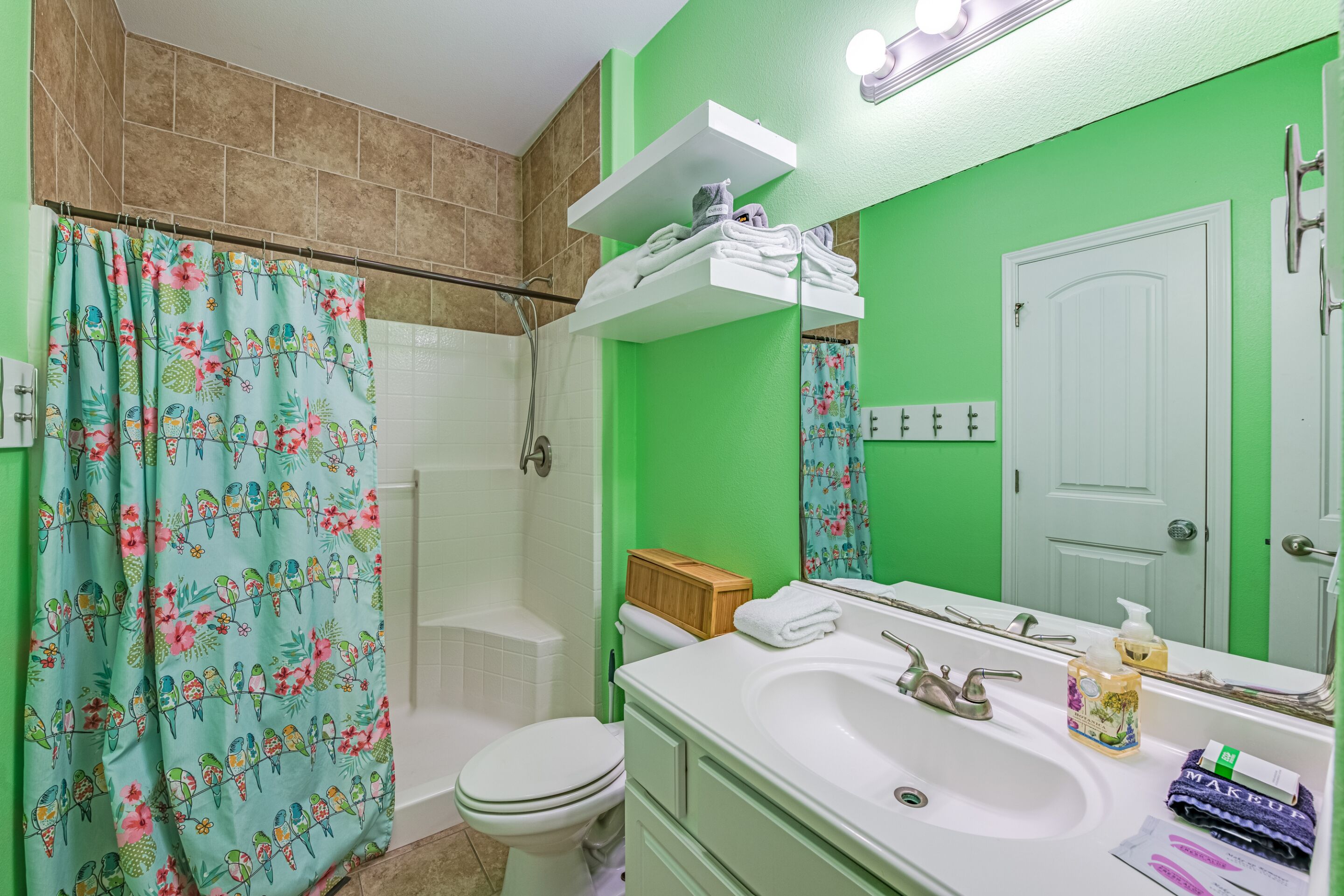A bathroom with a shower, toilet, and sink.