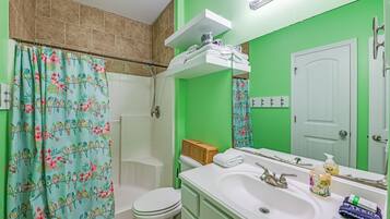 A bathroom with a shower, toilet, and sink.