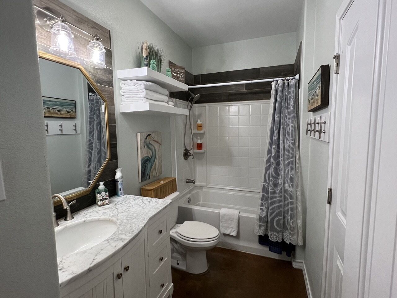A bathroom with a sink, toilet, bathtub, and shower curtain.