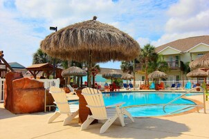 Una piscina al aire libre, sillones reclinables de piscina