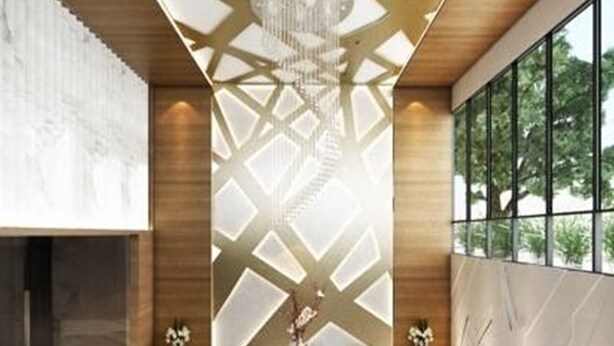A modern lobby with a geometric ceiling design, a central seating area with chairs, and a large window providing a view of greenery. - ibiz Boutique Hotel (Nakhon Si Thammarat)
