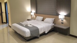A modern hotel room with a large bed, two bedside tables, and a patterned headboard. - ibiz Boutique Hotel (Nakhon Si Thammarat)