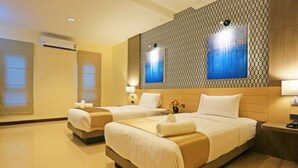 A hotel room with two beds, a patterned wall, and a large window. - ibiz Boutique Hotel (Nakhon Si Thammarat)