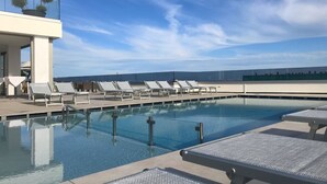 A pool area with lounge chairs and a view of the ocean. - Hotel Venice Beach (San Michele al Tagliamento)