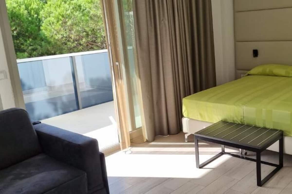 Un dormitorio con una cama, una mesita y una silla.