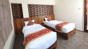 A hotel room with two beds, each with a wooden headboard and white bedding. - Dev Guest House (Lalitpur)