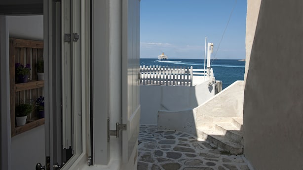 A view from a balcony overlooking a body of water with a boat in the distance. - Portes View House (Paros)