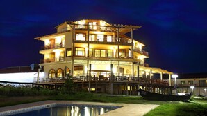 A multi-story hotel with outdoor seating and a pool. - Seven Generations Winery Hotel & SPA (Ivanovo)