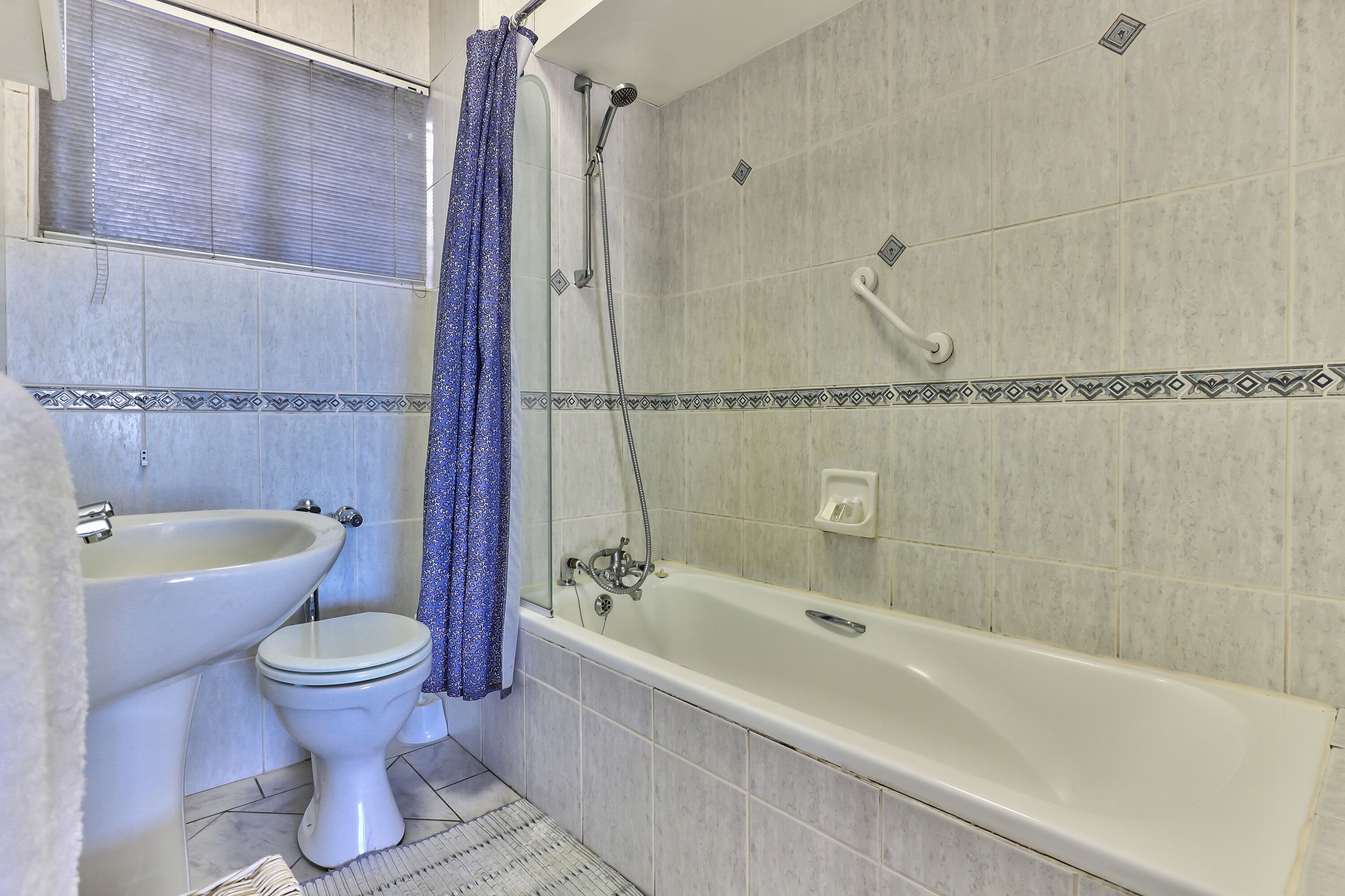 Un baño con bañera, inodoro y lavamanos.