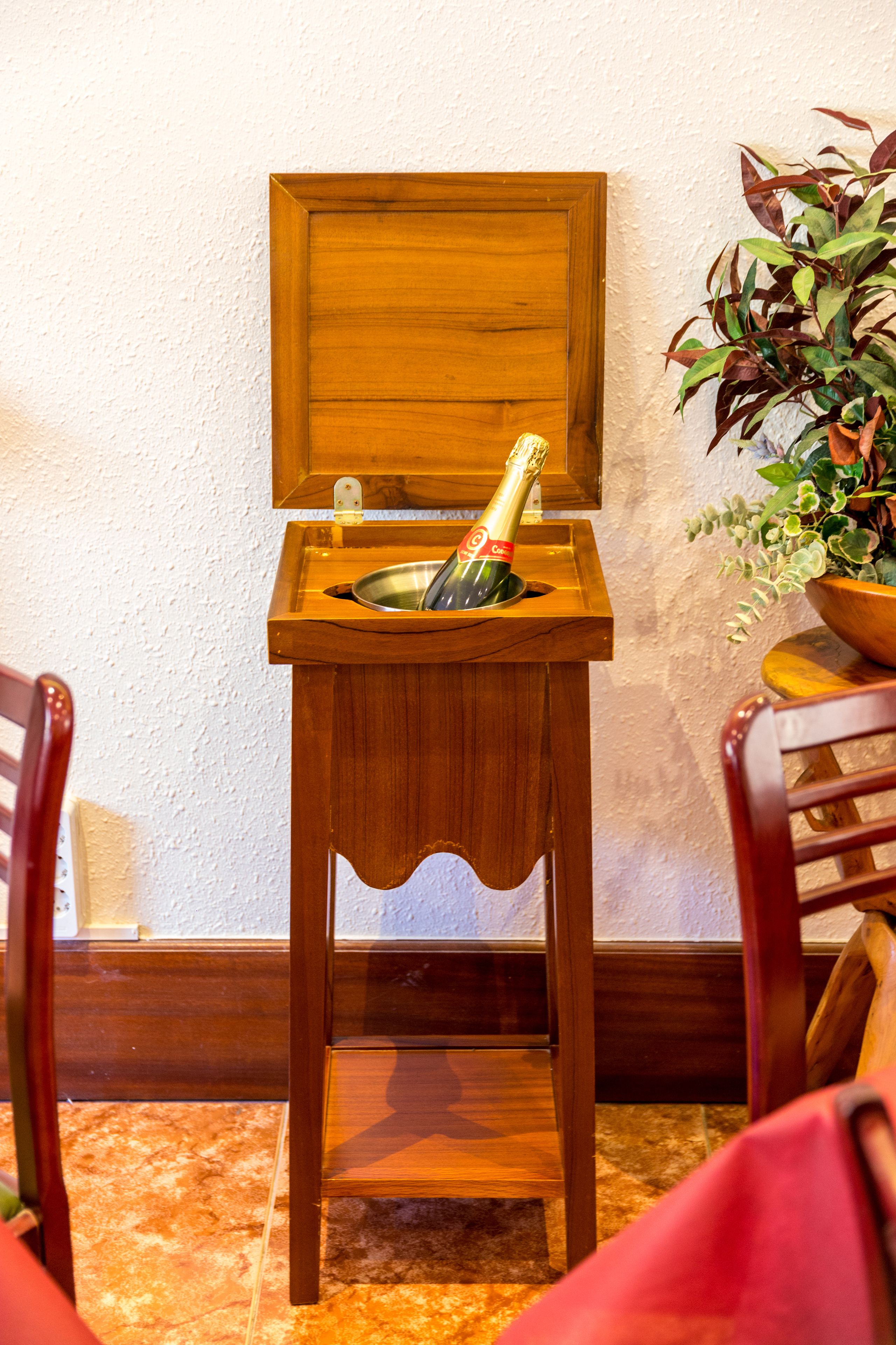 Ein Holzsideboard mit einer Champagnerflasche und einer Schale.