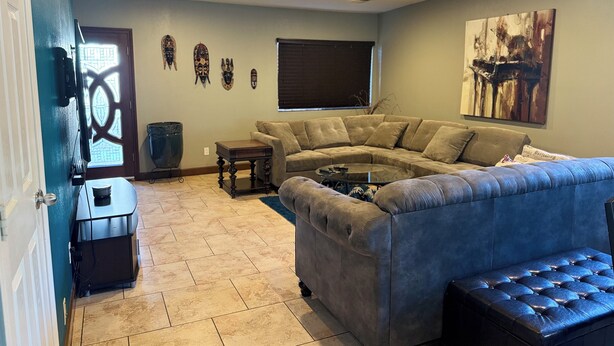 A living room with a sectional sofa, a blue armchair, and a coffee table. - Large Gorgeous home! Can sleep large groups (Long Beach)