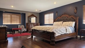 A bedroom with a large bed, wooden dresser, and a red rug. - Large Gorgeous home! Can sleep large groups (Long Beach)