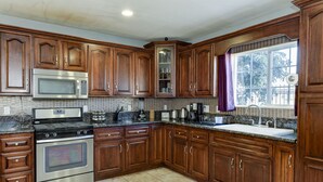 A kitchen with wooden cabinets, stainless steel appliances, and a window with a view. - Large Gorgeous home! Can sleep large groups (Long Beach)