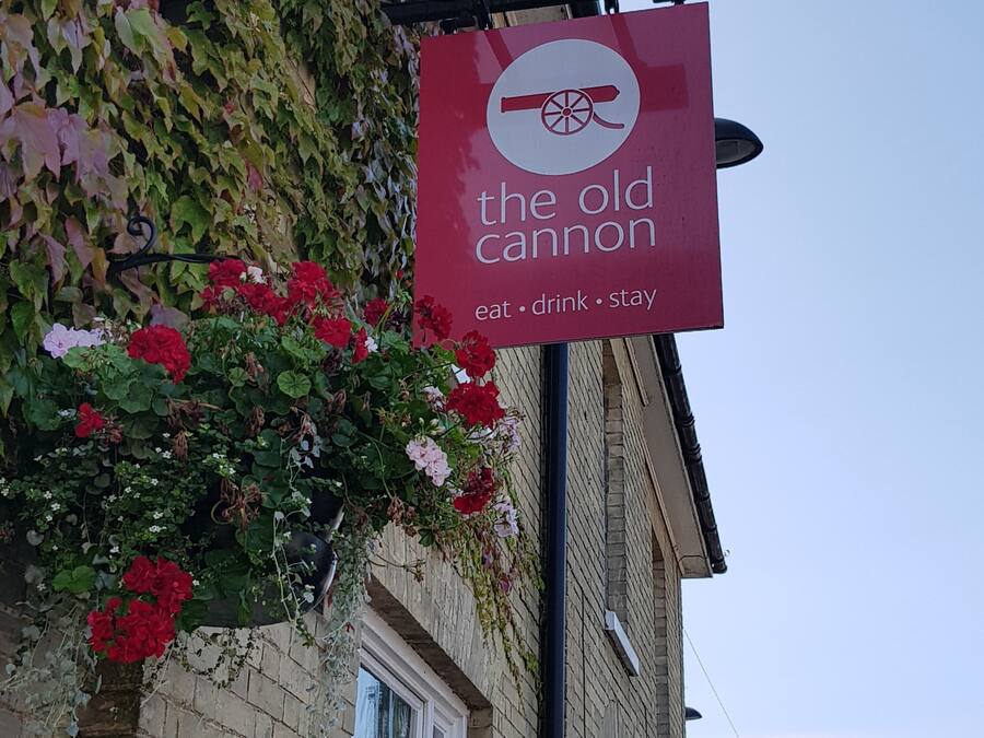 A sign for 'The Old Cannon' with a menu of eat, drink, and stay options.