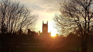 A church with a tall spire silhouetted against a sunset.