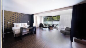 A modern hotel room with a bed, a desk, and a seating area. - Azur Hotel (Vari-Voula-Vouliagmeni)
