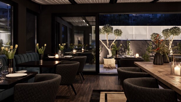 A modern dining area with dark wood furniture, candlelit tables, and a view of a garden through a glass wall. - Azur Hotel (Vari-Voula-Vouliagmeni)