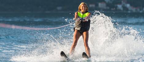 A person water skiing on a body of water with splashes around them.