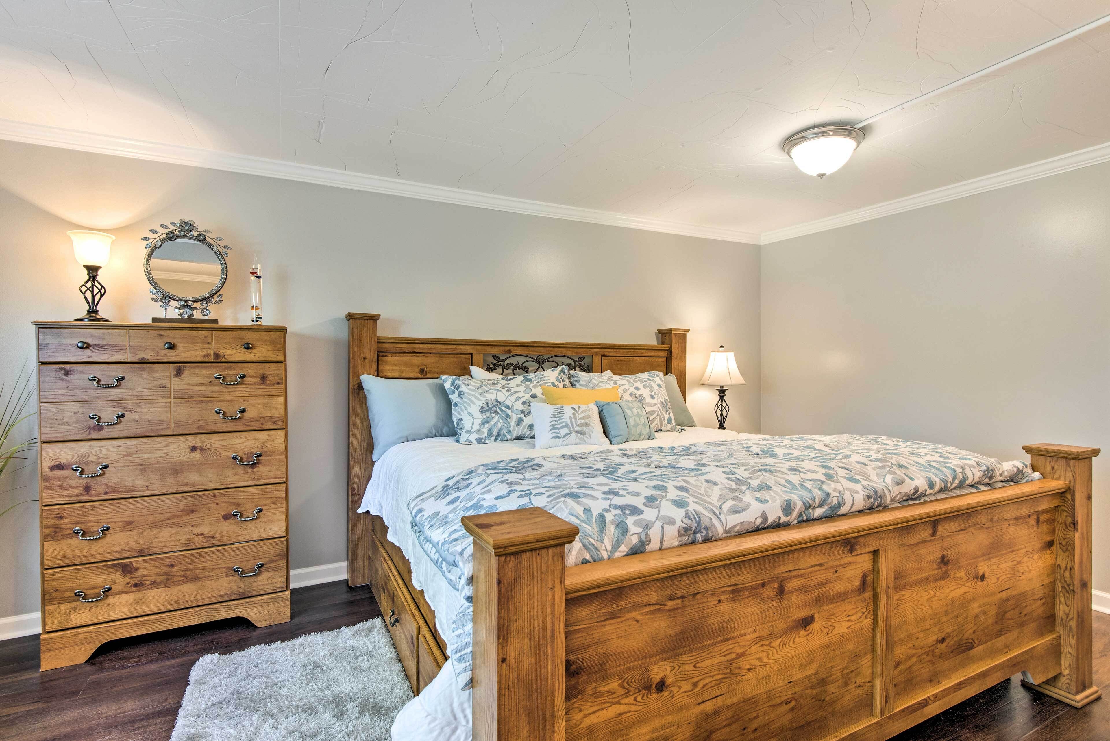 Un dormitorio con una cama de madera, un tocador y un espejo.