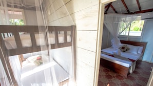 A room with a bed, a window, and a mosquito net. - Rüstic Beach Villa (Mundalama)