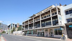 A multi-story building with a ground-level retail space and upper residential or office spaces. - Hill House 1 Bedroom (Cape Town)