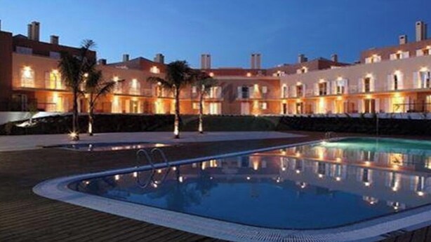 Un hotel con piscina, varias edificaciones e iluminación exterior.