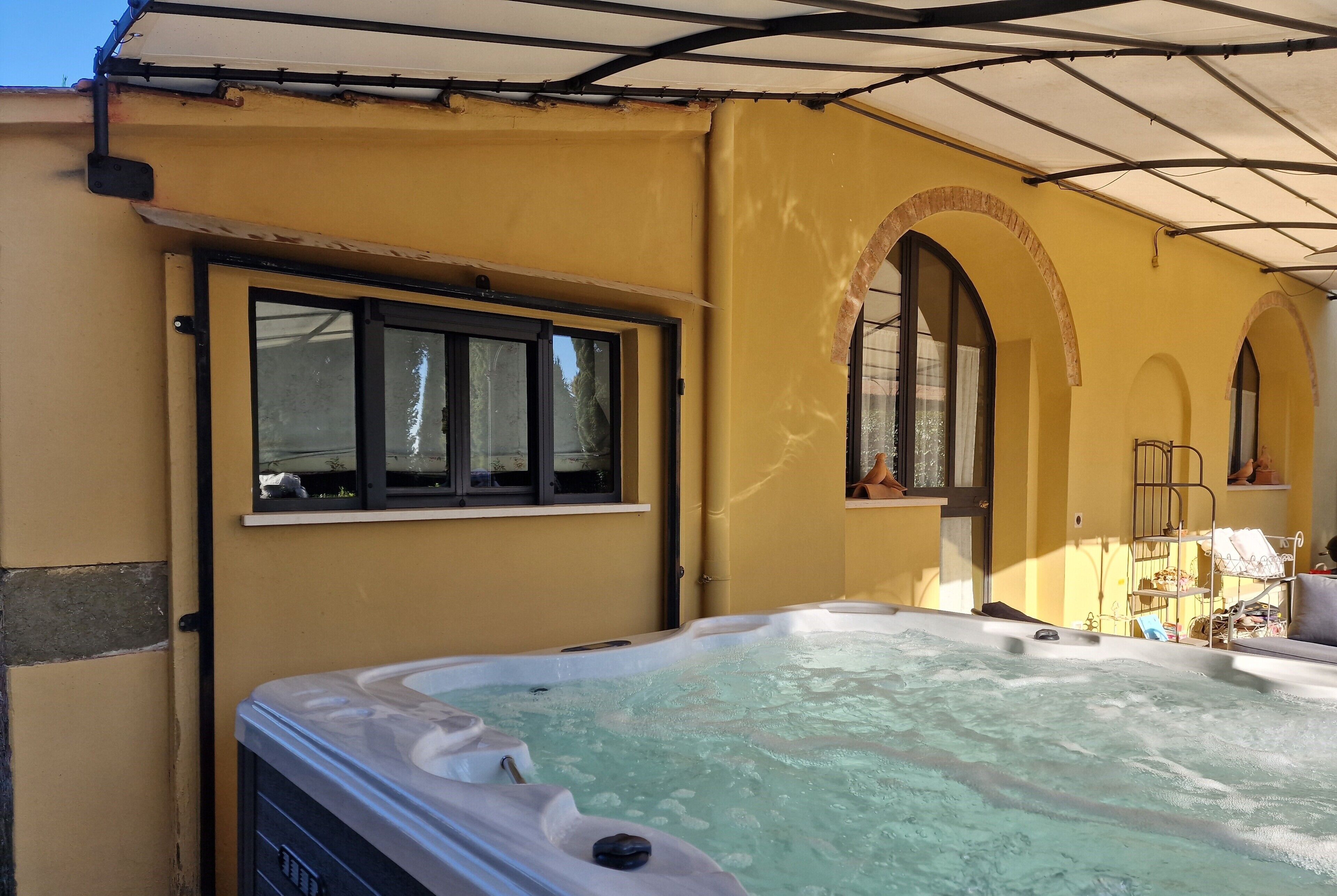 Zona de hidromasaje con pared amarilla, una ventana y un arco de entrada.