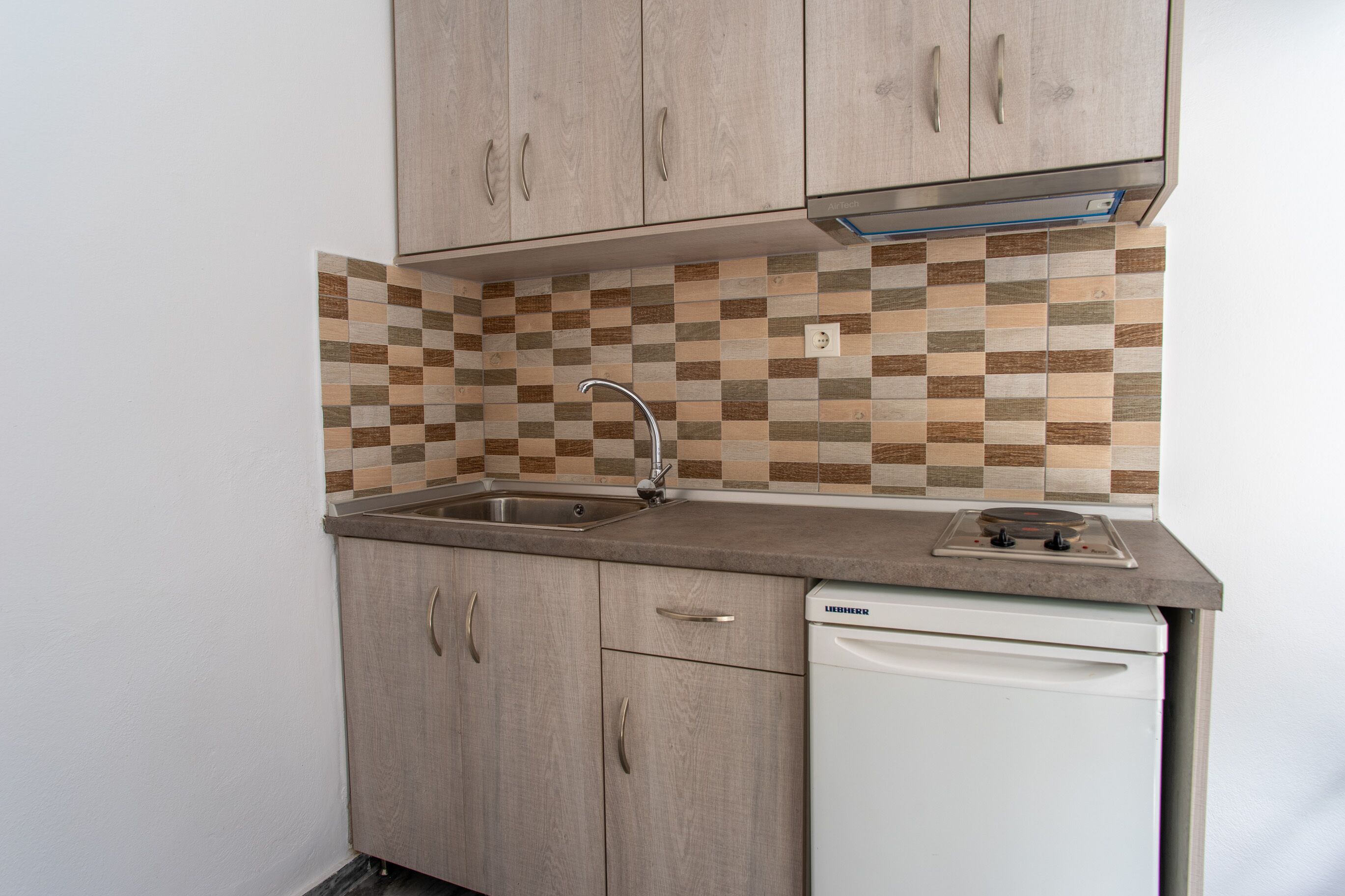 A compact kitchen with a sink, a stove, and a dishwasher.
